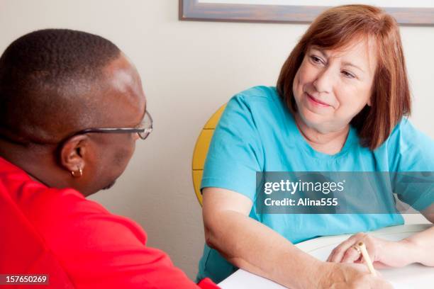social worker interviewing african-american man - maatschappelijk werker stockfoto's en -beelden