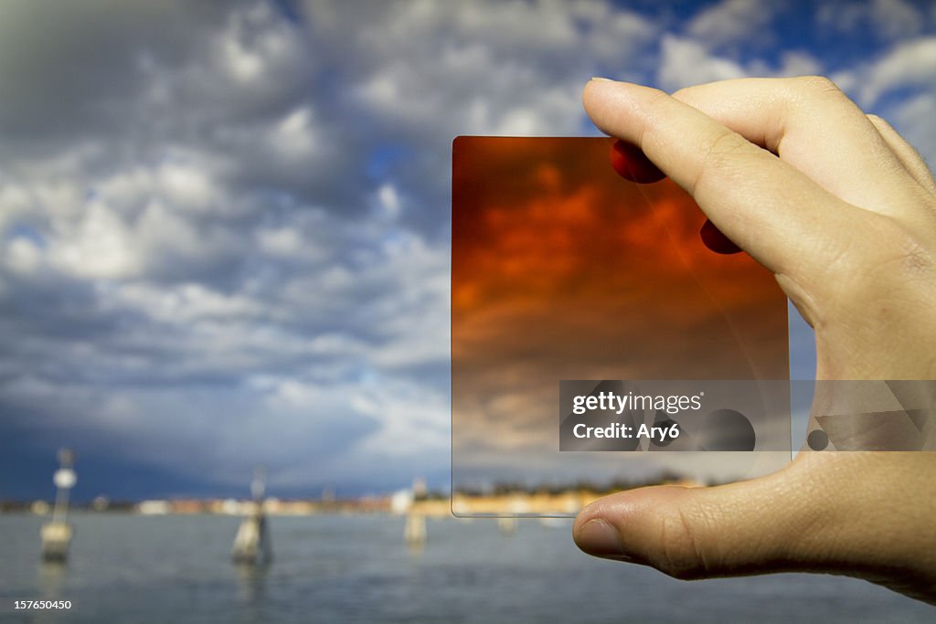 Equipo fotográfico de la mano (filtro) sobre fondo de venecia