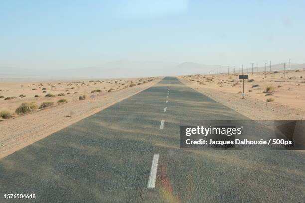 empty road along landscape against sky - vanishing point stock pictures, royalty-free photos & images