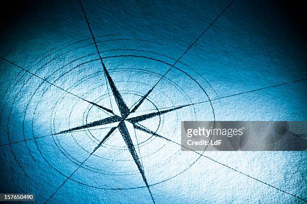 hand-drawn compass rose auf blauem papier - kompas stock-fotos und bilder