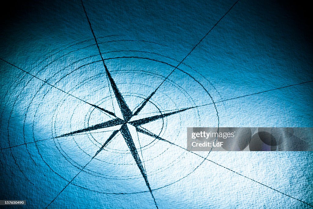 Hand-drawn compass rose on blue paper