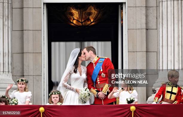 Britain's Prince William kisses his wife Kate, Duchess of Cambridge, on the balcony of Buckingham Palace, after the wedding service, on April 29 in...