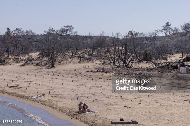 Families relax on Glistra beach on July 28, 2023 in Lardos, Rhodes, Greece. The popular beach was ravaged by wildfire that also destroyed the...