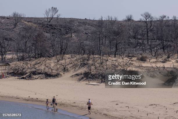 Families relax on Glistra beach on July 28, 2023 in Lardos, Rhodes, Greece. The popular beach was ravaged by wildfire that also destroyed the...