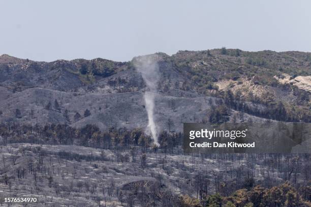Wind whips up the smoke on a hillside on July 28, 2023 in Asklipio, Rhodes, Greece. While firefighting planes and helicopters are still dealing with...