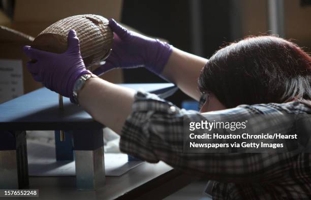 Wendy Adamson, Senior Museum Assistant for British Museum, carefully handles "The Cyrus Cylinder," an artifact from ancient Persia said to be the...
