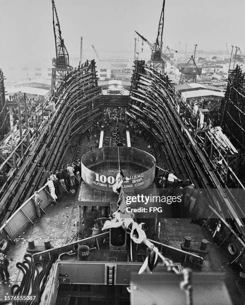 High-angle view of the launch of a United States Marine Corps ship, with a banner of the funnel reading '1000th USMC Ship, California Shipbuilding...