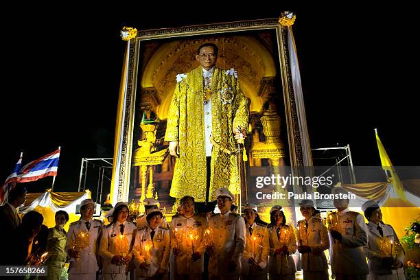 Thai royal nurses hold candles during celebrations to pay respect to Thailand's King Bhumibol Adulyadej on his 85th birthday December 5, 2012 in...