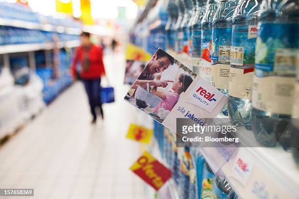 Real quality product sign hangs from an aisle beside water bottles inside a Real supermarket in Wroclaw, Poland, on Wednesday, Dec. 5, 2012. Metro...