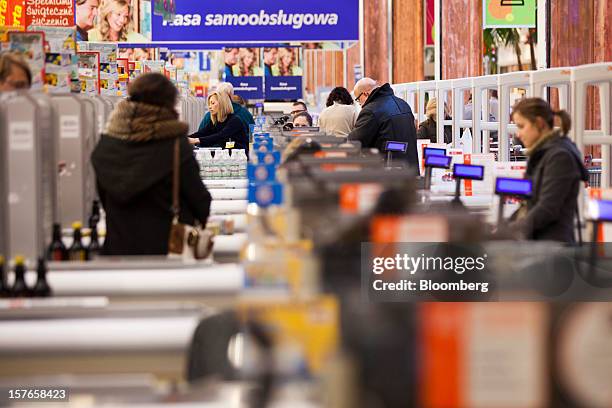 Employees work at checkout desks inside a Real supermarket in Wroclaw, Poland, on Wednesday, Dec. 5, 2012. Metro AG, Germany's biggest retailer,...