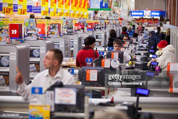 Employees work at checkout desks inside a Real supermarket in Wroclaw, Poland, on Wednesday, Dec. 5, 2012. Metro AG, Germany's biggest retailer,...