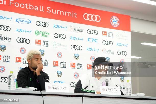 Thomas Tuchel of Bayern Muenchen speaks on and Serge Gnabry of Bayern Muenchen during the Bayern Muenchen press conference and training session at...