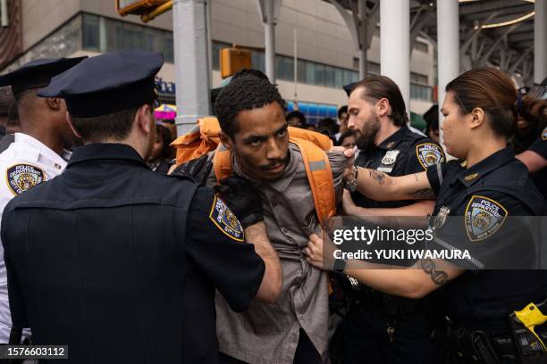 Police officers restrain a man during riots sparked by Twitch streamer Kai Cenat, who announced a "givaway" event in New York's Union Square on...