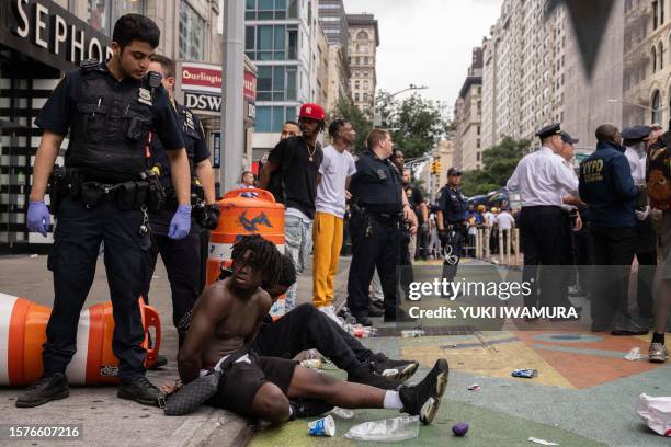 Police officers restrain people during riots sparked by Twitch streamer Kai Cenat, who announced a "givaway" event in New York's Union Square on...