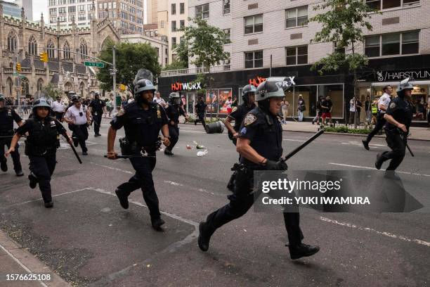 Police officers run towards the crowd during riots sparked by Twitch streamer Kai Cenat, who announced a "givaway" event, in New York's Union Square...