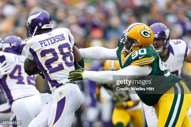 Raji of the Green Bay Packers reaches out to tackle Adrian Peterson of the Minnesota Vikings at Lambeau Field on December 2, 2012 in Green Bay,...