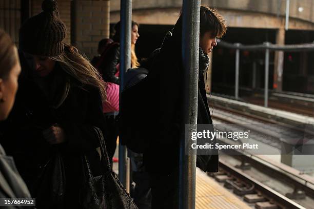 People wait for the subway at a stop in Brooklyn two days after a man was pushed to his death in front of a train on December 5, 2012 in New York...