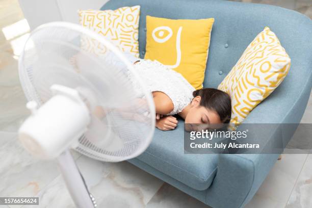 sleeping the child next to the fan - ac weary stockfoto's en -beelden