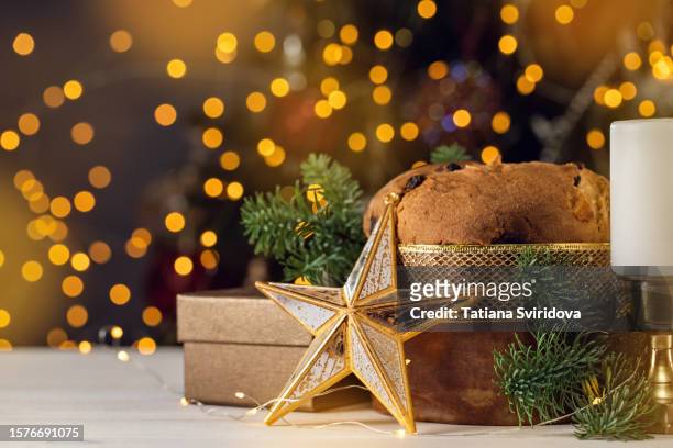 panettone fruit cake with christmas ornaments and candle - christmas cake stock pictures, royalty-free photos & images