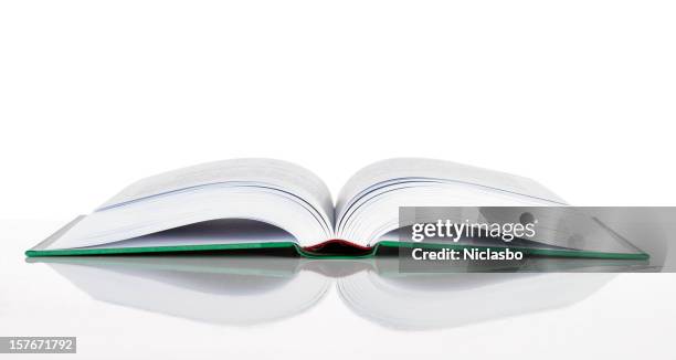 a hard cover book laid open on a white surface - los stockfoto's en -beelden