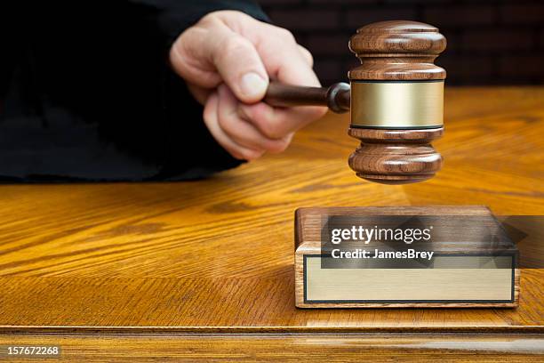 justice's hand pounds gavel to block with blank plaque - conviction stockfoto's en -beelden