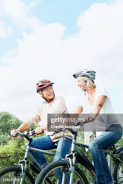 glücklicher reifer mann und frau auf zyklus fahren in der landschaft - old man bicycle stock-fotos und bilder