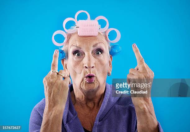 senior woman with obcene gesture - ugly woman stockfoto's en -beelden