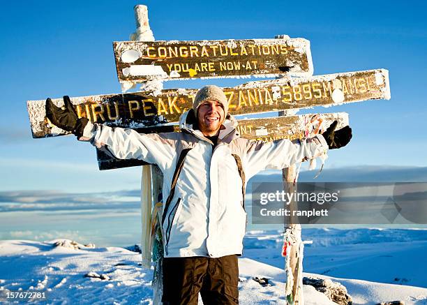 climber at the top of mount kilimanjaro - mt kilimanjaro stock pictures, royalty-free photos & images