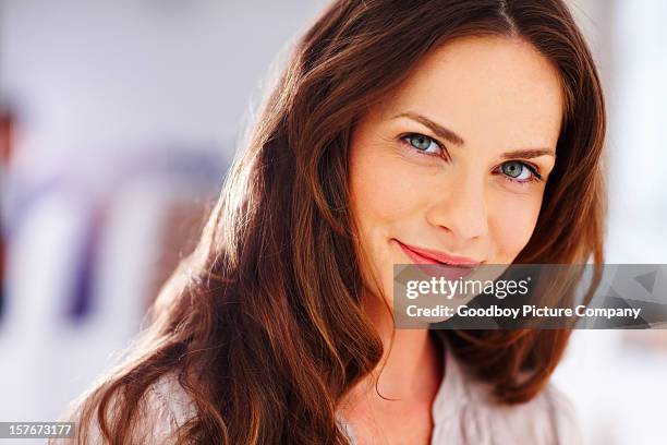 happy mature woman smiling against blur background - 40 year old models stock pictures, royalty-free photos & images