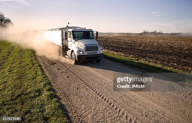 truck hauling grain on a dusty rural midwest road. - trucking industry stock pictures, royalty-free photos & images