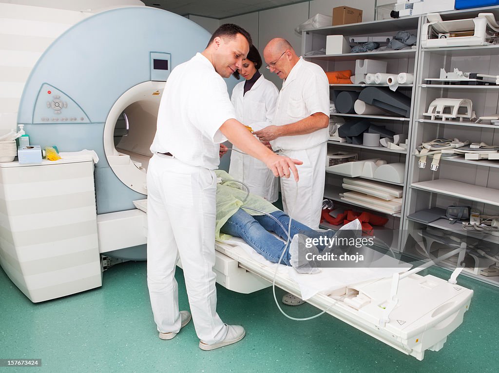 Jovem Menina em RMN machine.doctors e técnico consulta