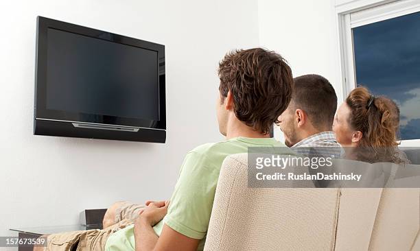 family watching movie. - family watching tv from behind stockfoto's en -beelden