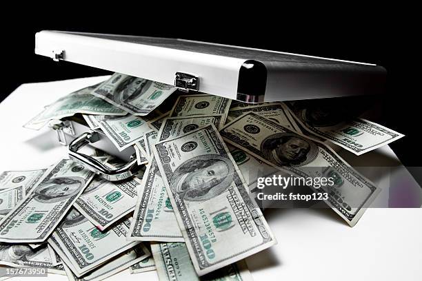 $100 dollar bills spilling out of suitcase. - gestolen-goederen stockfoto's en -beelden