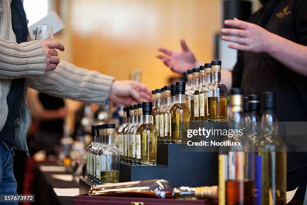 man looking at a whiskey bottle display - whiskey stock pictures, royalty-free photos & images