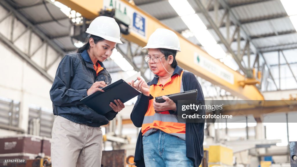 Senior female supervisor training engineer in factory.
