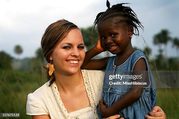 american woman holding african girl - miss sierra leone stock pictures, royalty-free photos & images