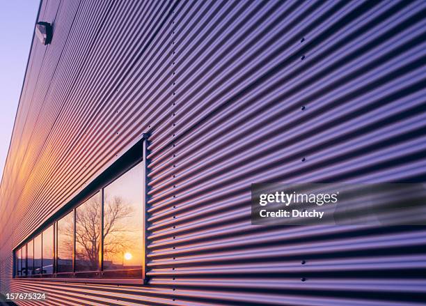 sunset reflecting in window of warehouse. - façade stock pictures, royalty-free photos & images