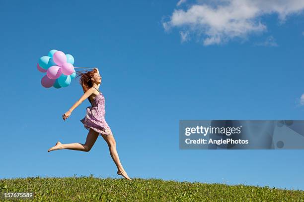 幸せな女性をジャンピング meadow に風船 - barefoot redhead ストックフォトと画像