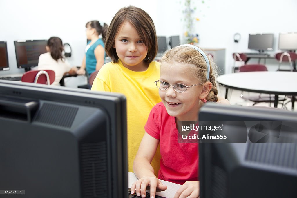 Dos niños niñas feliz en clase de informática