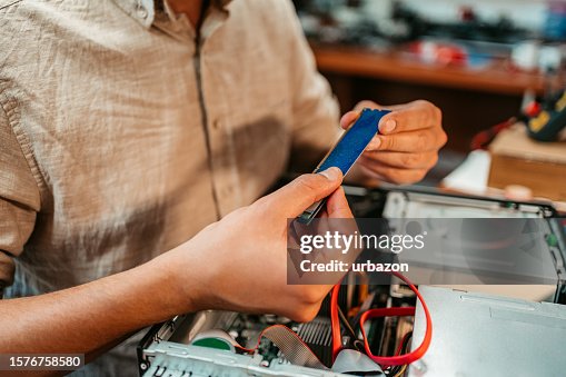 Young Man Checking RAM Component In A Workshop Young Man Checking RAM Component In A Workshop