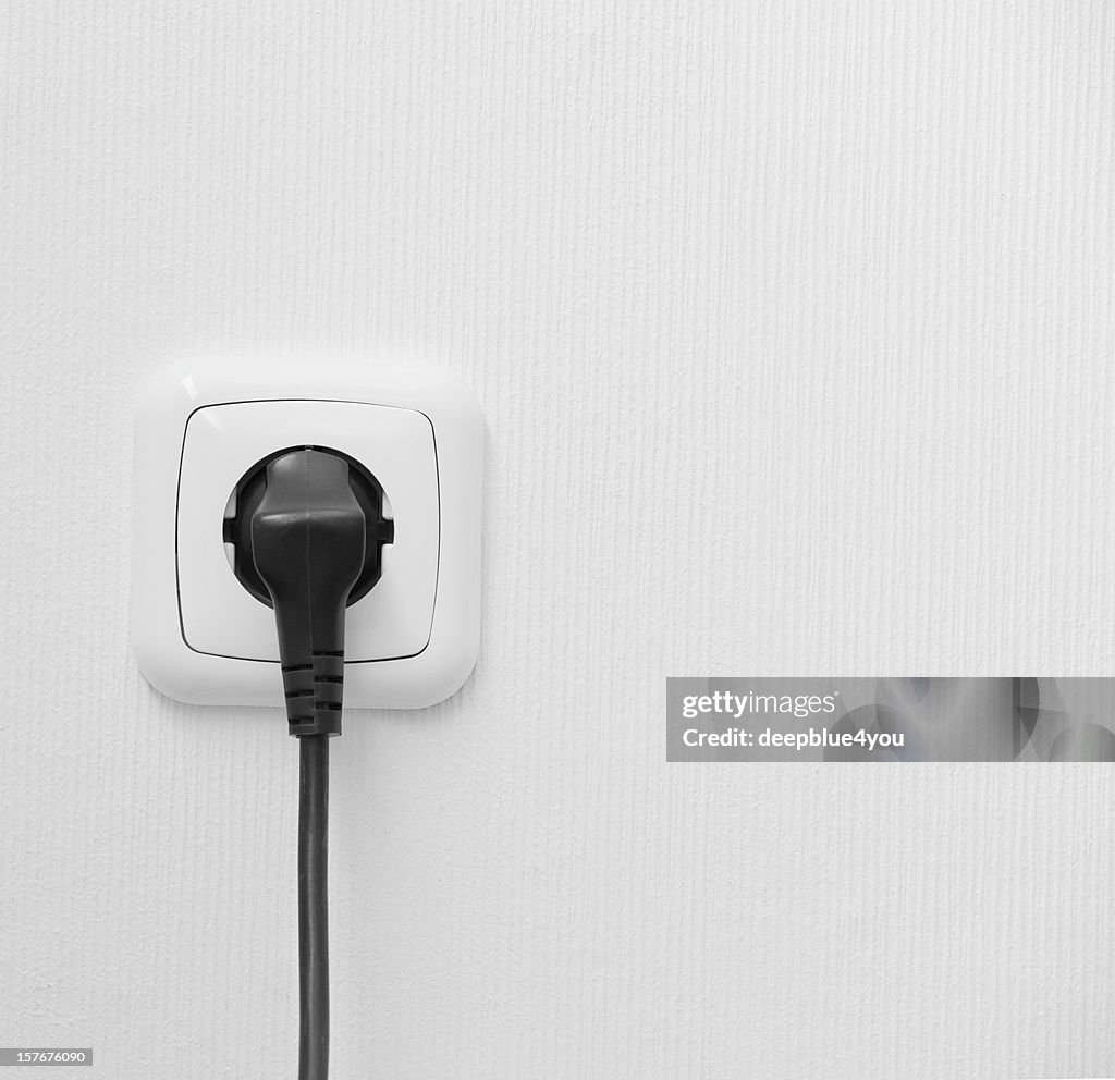 Brand new outlet on a white wall with plug