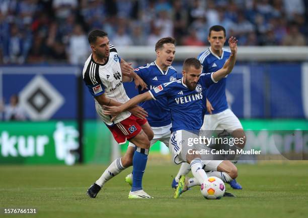 Dominick Drexler of FC Schalke 04 is challenged by Levin Oeztunali of Hamburger SV during the Second Bundesliga match between Hamburger SV and FC...