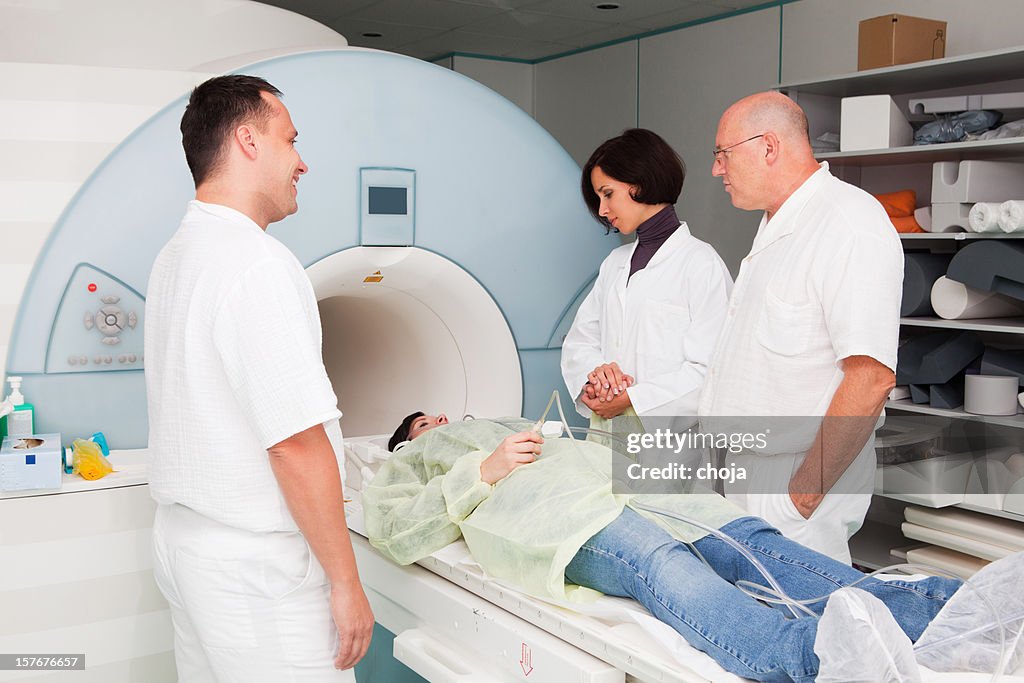 Young girl in MRI machine...doctors and technician consulting