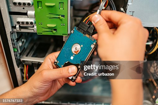 Technician Installing Hard Drive Component In A Workshop Technician Installing Hard Drive Component In A Workshop
