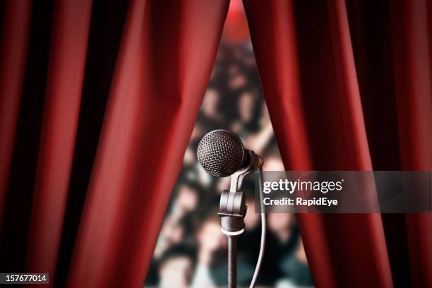 microphone and out of focus audience through red drapes - stage curtain stock pictures, royalty-free photos & images