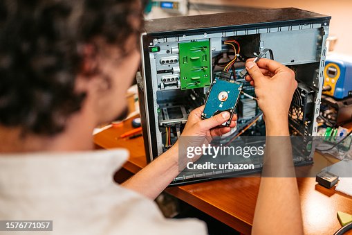 Technician Installing Hard Drive Component In A Workshop Technician Installing Hard Drive Component In A Workshop
