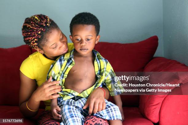Princess Sawbo embraces her son Prince Sawbo while revealing his scars from heart surgery on July 2 in Houston, Tx. Princess Sawbo, a refugee from...