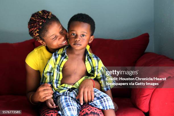 Princess Sawbo embraces her son Prince Sawbo while revealing his scars from heart surgery on July 2 in Houston, Tx. Princess Sawbo, a refugee from...