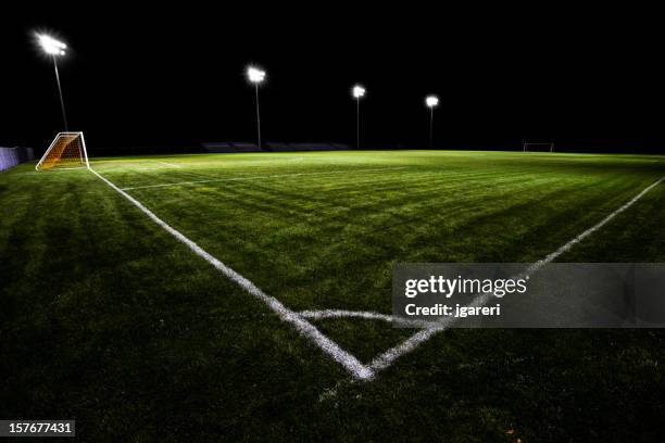 fußballplatz bei nacht - flutlichter stock-fotos und bilder