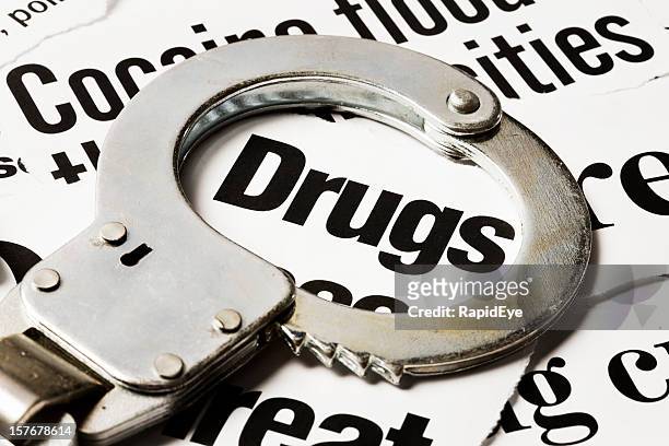 handcuff circles 'drugs' in pile of headlines about drug crime - drug gang stock pictures, royalty-free photos & images